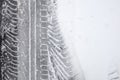 Detail of car wheel prints on snow