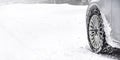 Detail of car winter tire - snow covered road, wide banner, empty space for text left. all logos brands on tyre removed