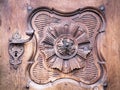 Detail of a carved wooden portal with wrought iron handle. Royalty Free Stock Photo