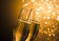 Detail of champagne flutes with golden bubbles on dark golden light bokeh background Royalty Free Stock Photo