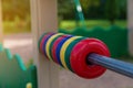 Detail of a children`s playground in the park. Plastic abacus on a steel rod on a green background on a bright summer day