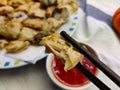 Detail of chopsticks holding one piece of fried oyster mushroom