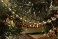 Detail of Christmas ornaments. Tinsel and pearl garlands in red and gold colors Royalty Free Stock Photo