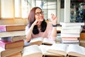 Young woman thinking while studying in library