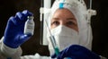 Detail closeup of syringe needle and ampoule , nurse taking injection shot,hands in blue protective gloves holding