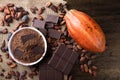 Detail of cocoa fruit with pieces of chocolate and cocoa powder on raw cocoa beans Royalty Free Stock Photo