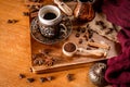 Detail of a coffee cup surrounded by coffee beans and spices on a natrual wood background Royalty Free Stock Photo