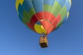 Detail of colorful hot air balloon heading up in blue sky. Close up Royalty Free Stock Photo