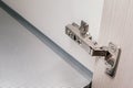 Detail of concealed hinge on cabinet door