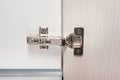 Detail of concealed hinge on cabinet door, furniture fitting hardware for cupboard or wardrobe