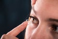 Detail of a contact lens on a woman's finger which is putting on lens to his eye. Royalty Free Stock Photo