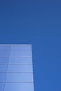 Detail of a contemporary building with glass facade and blue sky Royalty Free Stock Photo