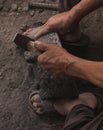 Detail of the craftsman`s hands carving the stone to make molcajetes