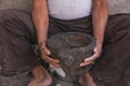 Detail of the craftsman`s hands carving the stone to make molcajetes