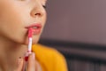 Detail cropped shot of unrecognizable charming woman with red hair applying lipstick holding mirror and looking at Royalty Free Stock Photo