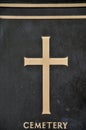 Detail of cross on tombstone in cemetery. Engraving with christian religious symbol in close up Royalty Free Stock Photo
