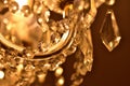 Detail of crystal ornaments on antique chandelier. Warm white color balance. Vertical photo.