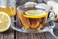 detail of cup of ginger tea with lemon and fresh ginger on wooden cutting board Royalty Free Stock Photo