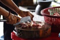 Cutting pork by knife on wood chopping board prepare cook for party.