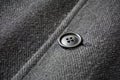 Detail of a dark button fastening the fish bone winter coat