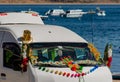 Detail of decorated van with religious bouquets and garlands with Titicaca Lake in the background. Copacabana, Bolivia