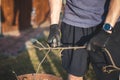 Detail of the deployment of a young temporary worker in a forest environment while cutting branches. Sharp scissors cut through a