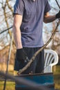 Detail of the deployment of a young temporary worker in a forest environment while cutting branches. Sharp scissors cut through a