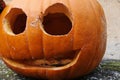Detail of doubed out Jack O lantern orange halloween pumpkin, smiling with round eyes