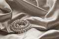 Detail of draped beige silk with pearl jewelry