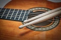 Detail of drumsticks on acoustic guitar