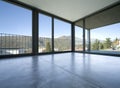 Detail of empty living room with large windows giving on the mountains