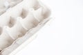 Detail of empty and open recycled cardboard egg carton in the corner of the image on a white background. Royalty Free Stock Photo