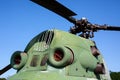 Detail of engine cover housing and rotors of an old military helicopter against blue sky