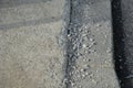 Detail of erosion of the concrete surface of the road near the highway due to heavy frost and salting against snow tears the concr