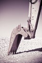 Detail of excavator\'s bucket at a gravel seaside Royalty Free Stock Photo