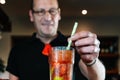 detail of an experienced bartender stirring a cocktail with a straw. Preparing a cocktail in a nightclub.