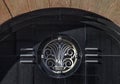 Detail of exterior Art Deco architectural style terracotta building with doorway arch and metal emblem on black grainite