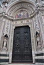 Detail of the facade of the Cathedral of Santa Maria del Fiore, with the large and dark door probably made of bronze, the large fr