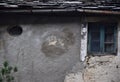 Detail of the facade of an old house, with oval and window with glass made opaque by time, in Vergemoli. Royalty Free Stock Photo