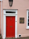 Detail from the facade of a pink cottage with a bright red door in the county of Essex, United Kingdom. Royalty Free Stock Photo