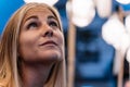 Detail of the face of a blonde girl looking at the sky decorated with Chinese lanterns out of focus in the background Royalty Free Stock Photo