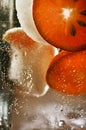 Detail of falling sliced orange into the glass of water