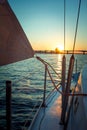 Detail of fastening the sail on a yacht in the rays of the sunset. Shooting on board a yacht on the river Royalty Free Stock Photo