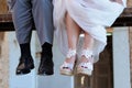 Detail of the feet of the groom and the bride sitting on a scaffolding