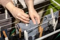 Detail of female hands hanging the washing out to dry on a drying rack; woman hanging wet clothes on a drying rack with clothes Royalty Free Stock Photo