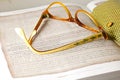 DETAIL ON FRAME OF OLD READING GLASSES ON AN OPEN BOOK Royalty Free Stock Photo
