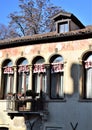 Detail, with French windows and balcony, of a historic house illuminated, in part, by the sun in the blue sky. Royalty Free Stock Photo