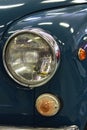 Detail of front mask with headlight and blinkers on veteran italian compact car