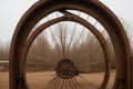 Detail of a frost-covered wagon wheel leaning on a barn