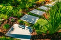 Detail of garden path with stone slabs with bark mulch and native plants. Landscaping and gardening concept